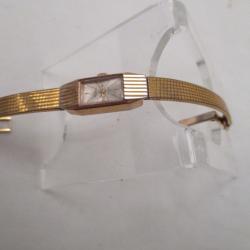 une montre  bracelet de femme    plaqué or  -  marque  astral   - fonctionne