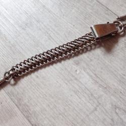 Bélière réglementaire en métal pour le port du sabre suisse.